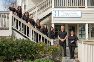 Darnell dental team standing together in front of dentist office in Hollister, CA